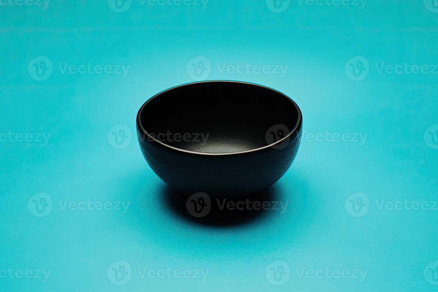 Empty black bowl on a teal background photo