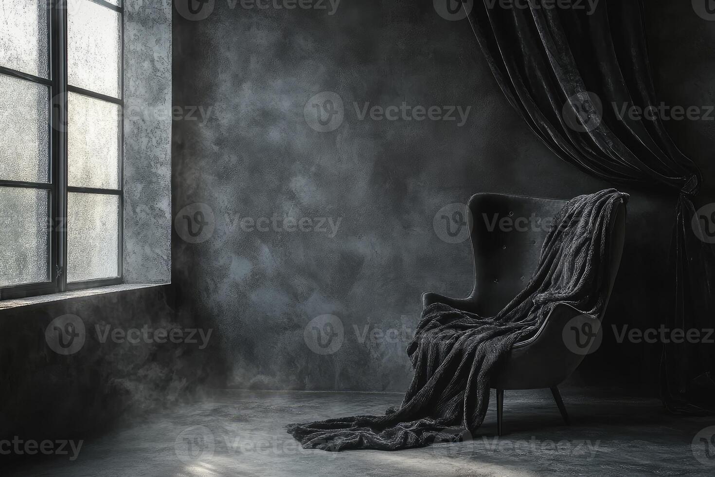 Dark, moody room with dramatic lighting and a single armchair draped in a dark fabric photo