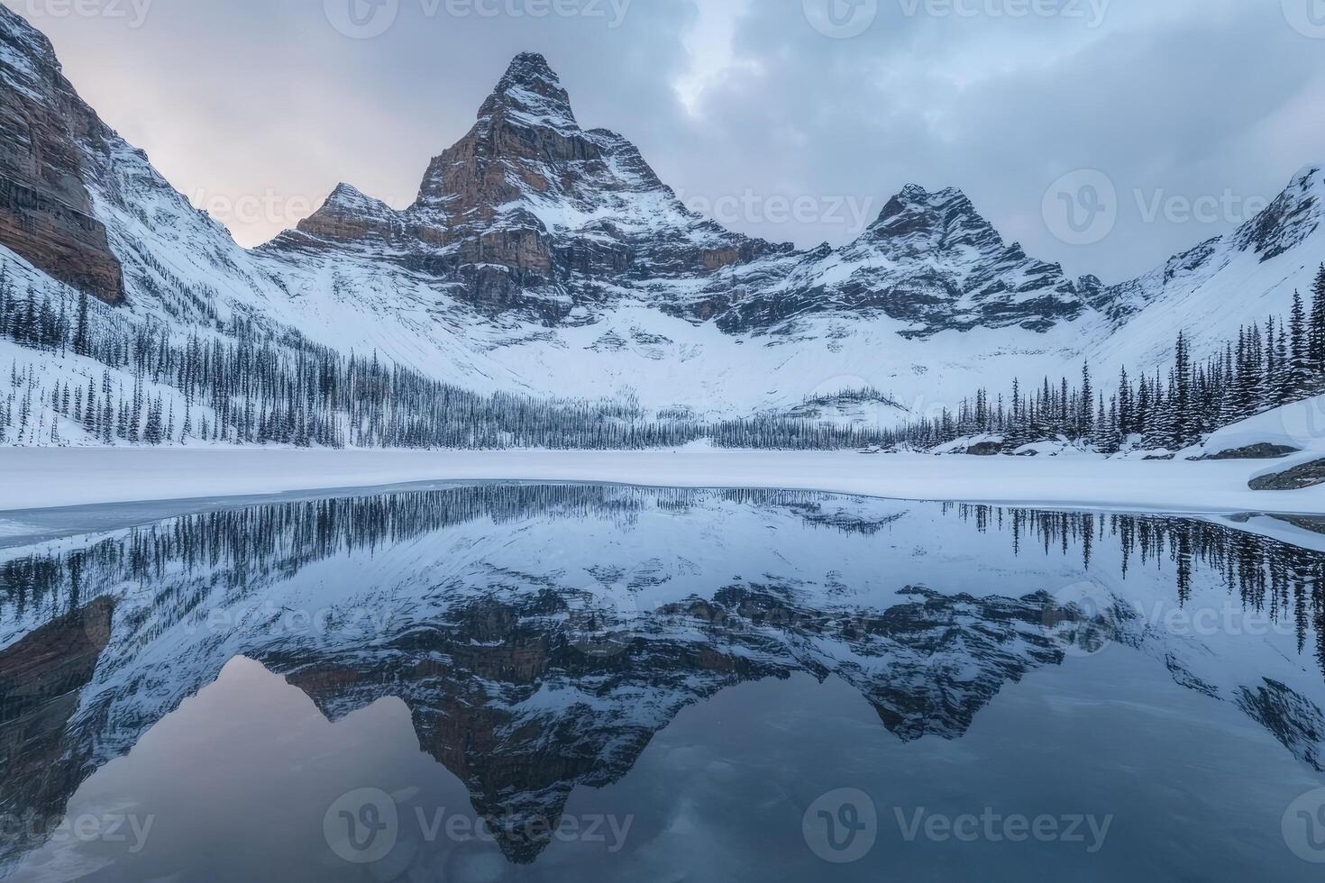 Frozen alpine lake reflecting snow-capped peaks photo