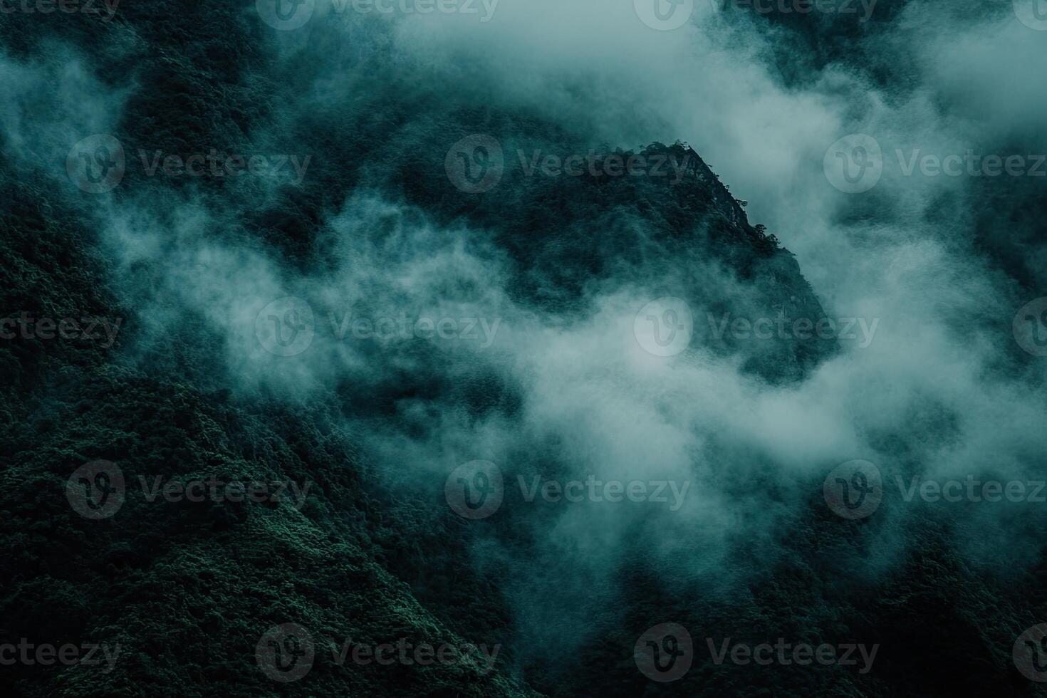 Misty mountain range shrouded in a dense cloud cover photo
