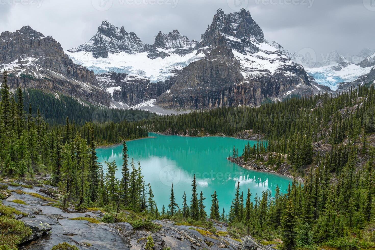 Majestic alpine lake nestled amidst snow-capped peaks. Lush forest surrounds tranquil turquoise water photo