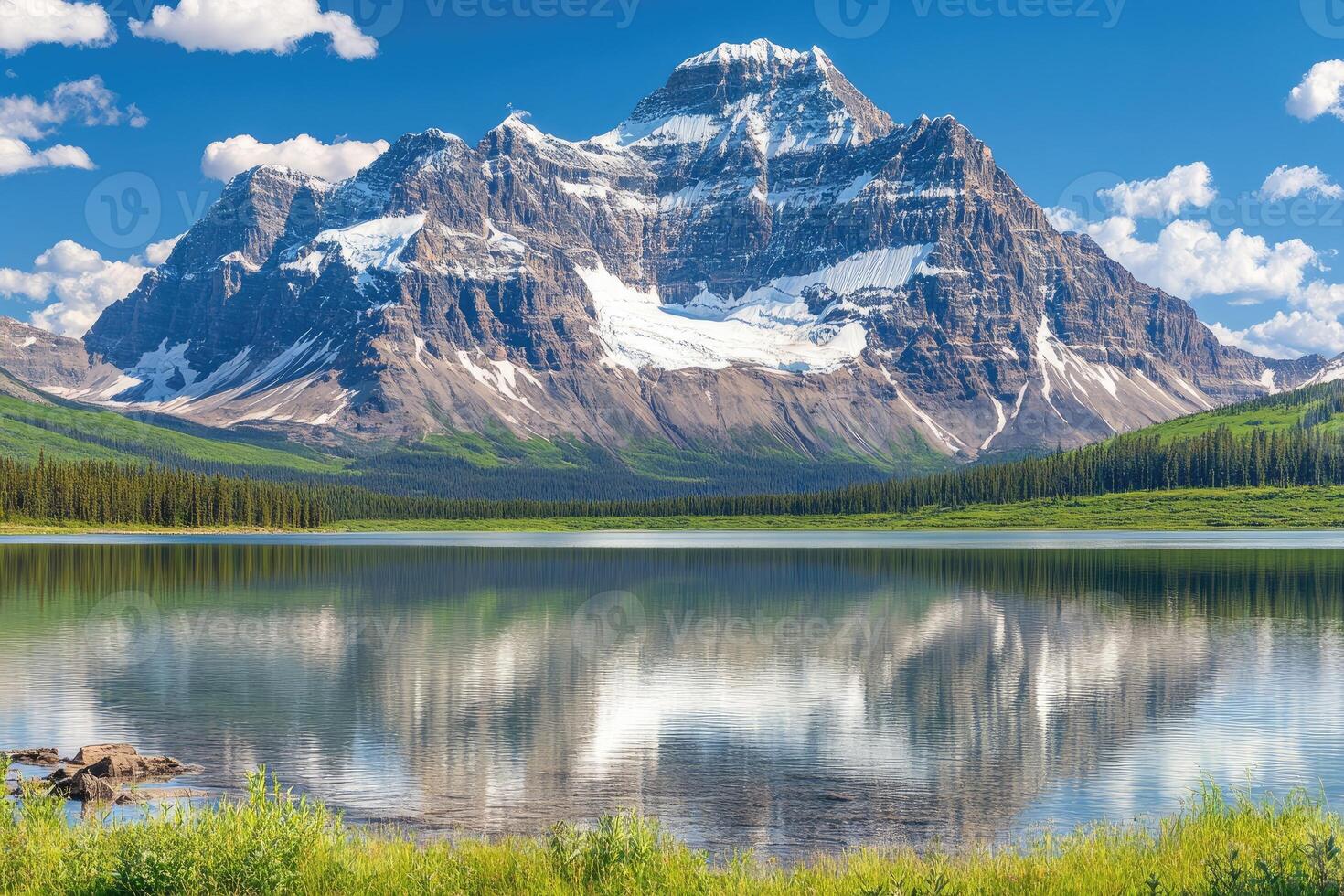 Majestic mountain reflected in a serene lake. Lush valley and snow-capped peak photo