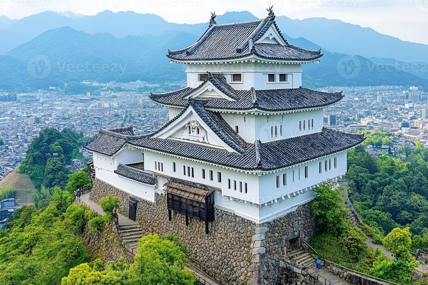 Ancient Japanese castle atop a hill overlooking a city photo