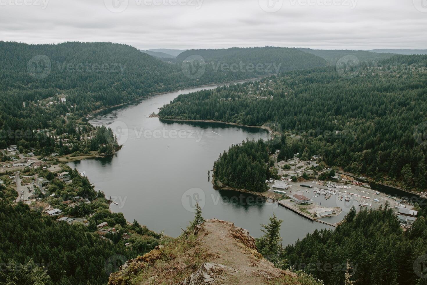 Panoramic view of a winding river valley. Dense forest surrounds a town nestled along the water photo