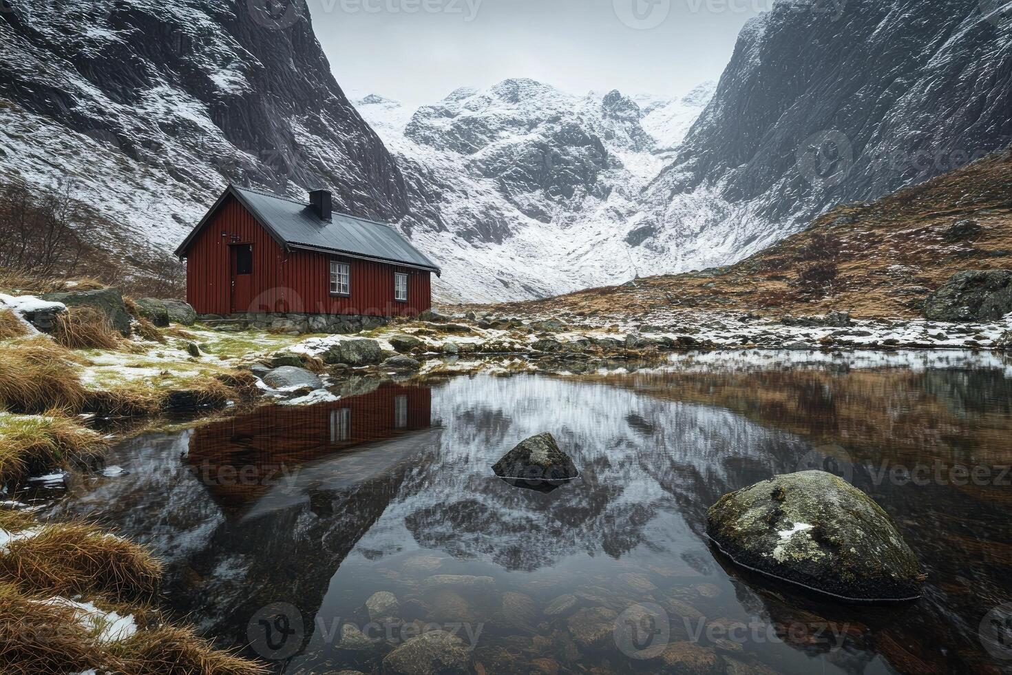Rustic cabin nestled amidst snowy mountains, reflecting in a tranquil pond photo