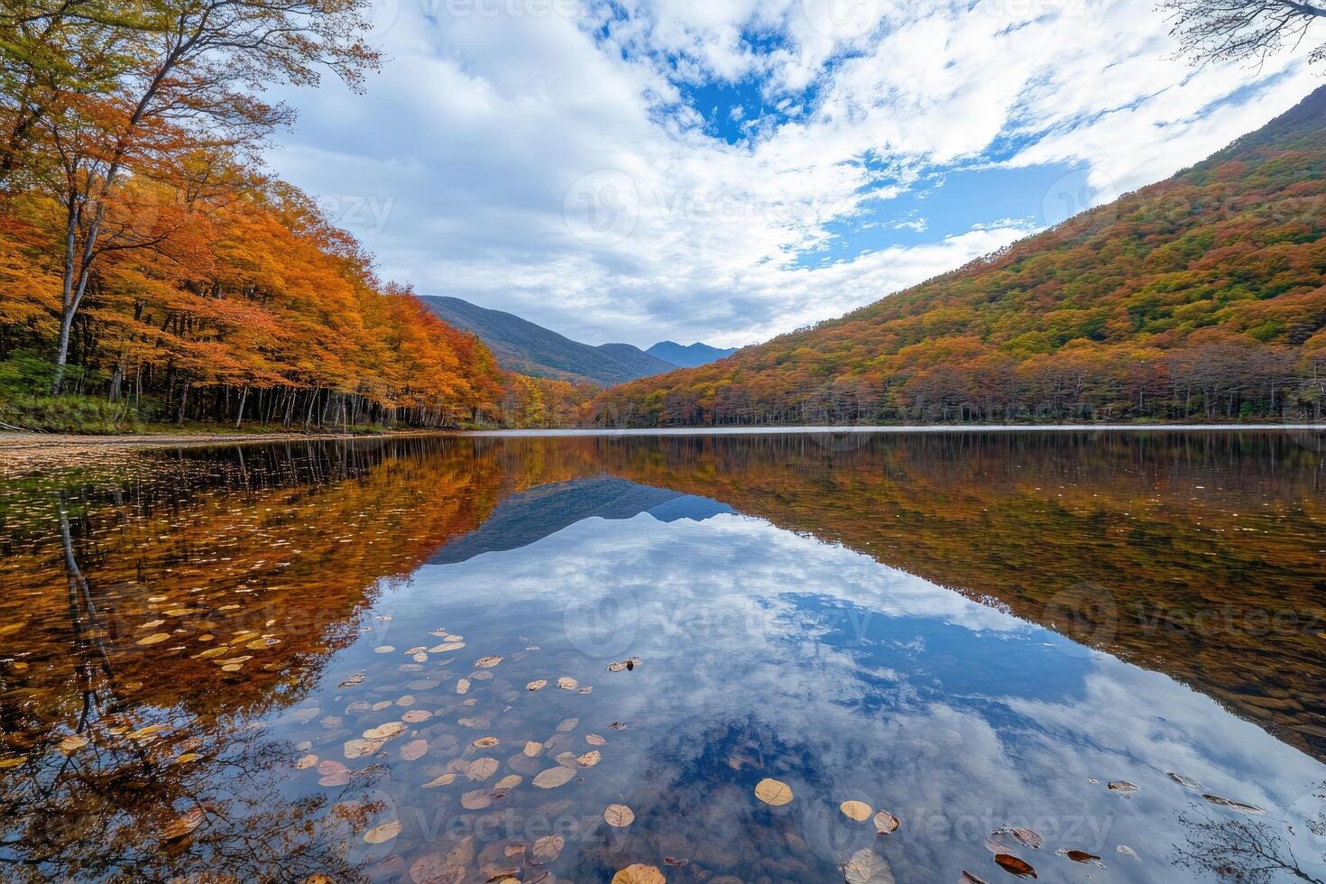Autumnal lake reflections. Tranquil autumn scene with vibrant fall colors mirrored on a calm lake. Mountains rise in the background photo