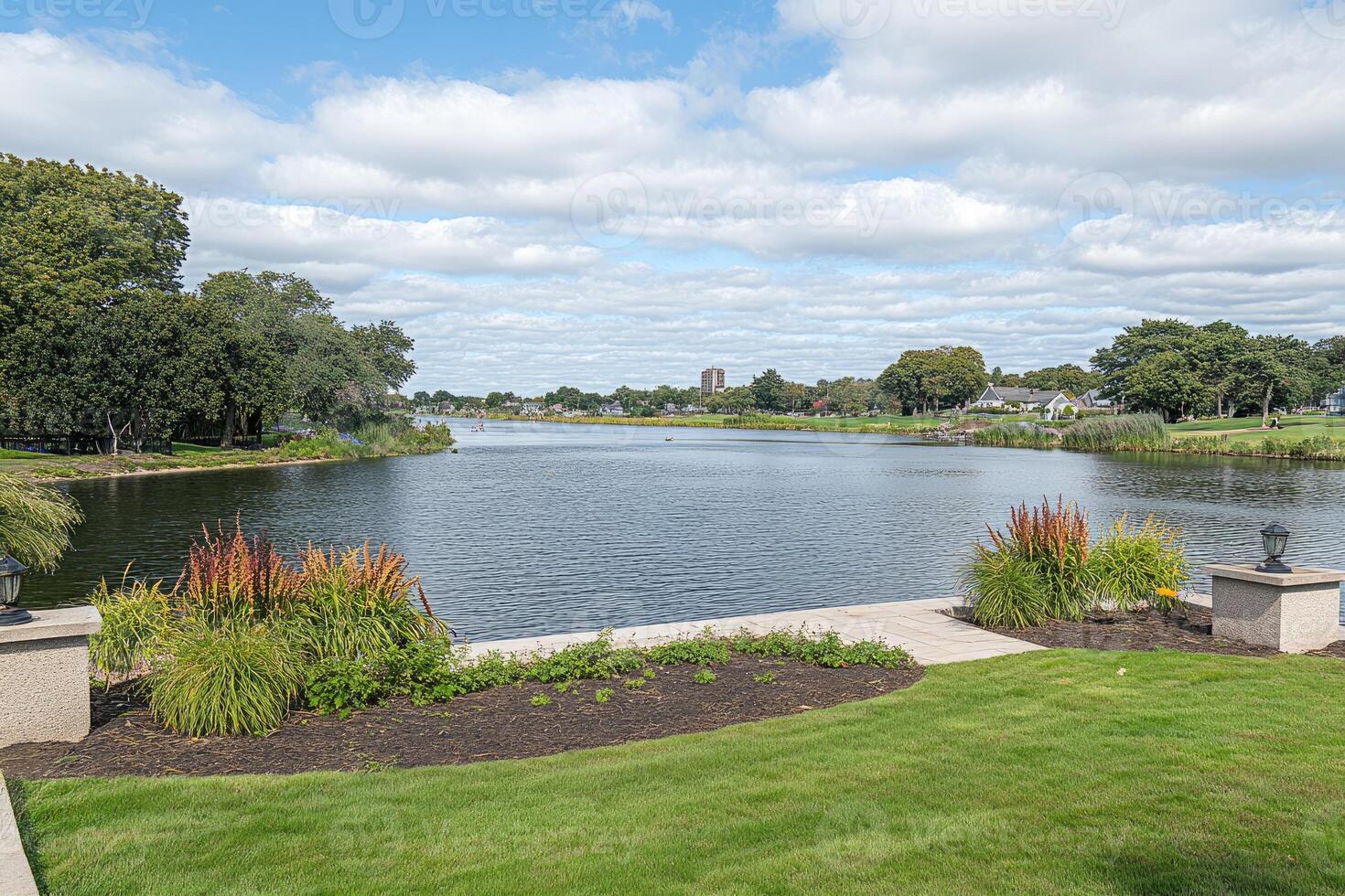 Tranquil lake vista with manicured grounds photo
