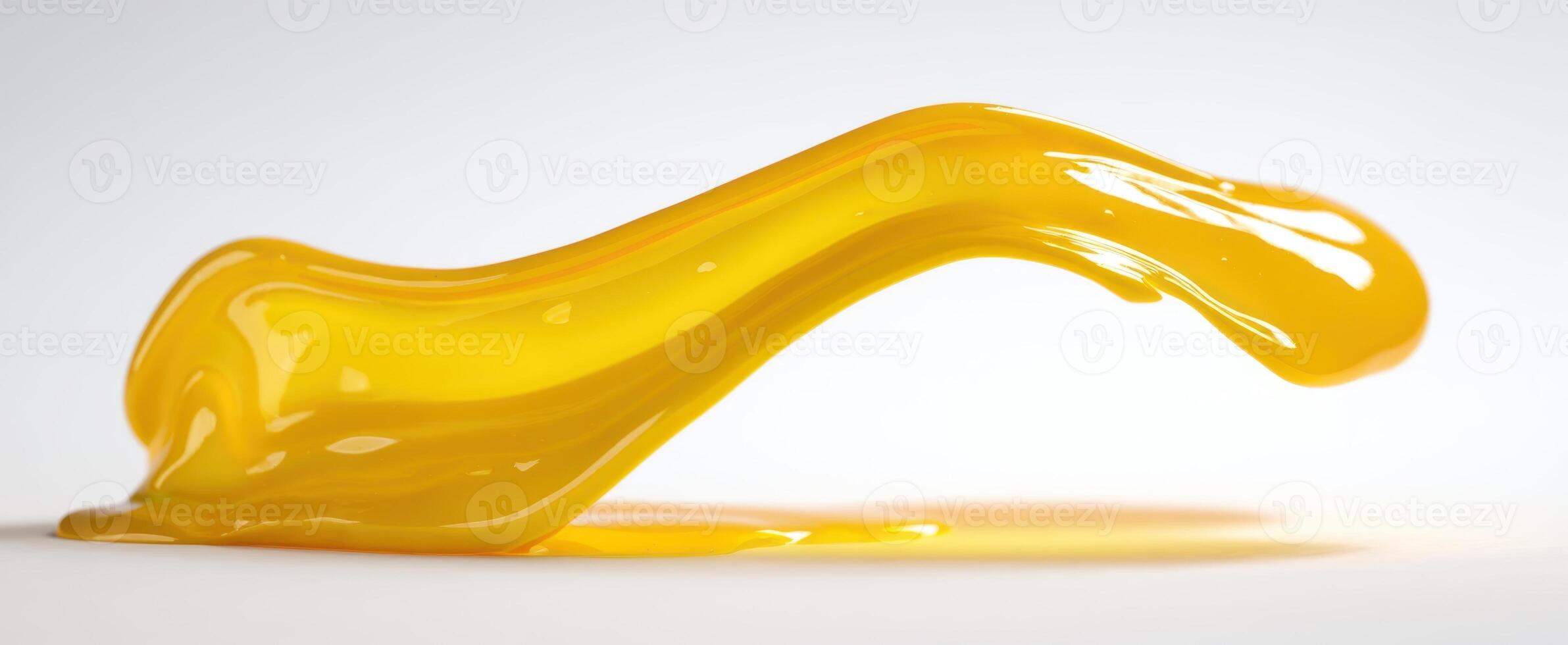 The flowing yellow liquid showcasing a glossy texture and smooth contour. photo