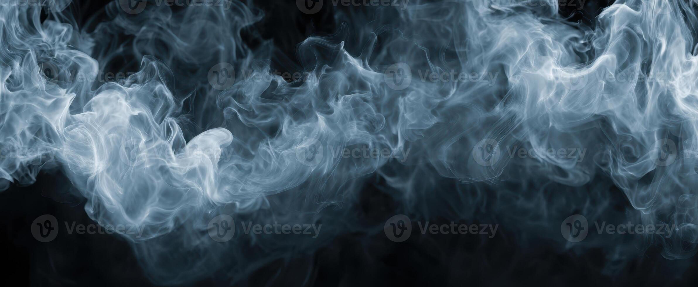 The swirling patterns of ethereal smoke against a black background. photo