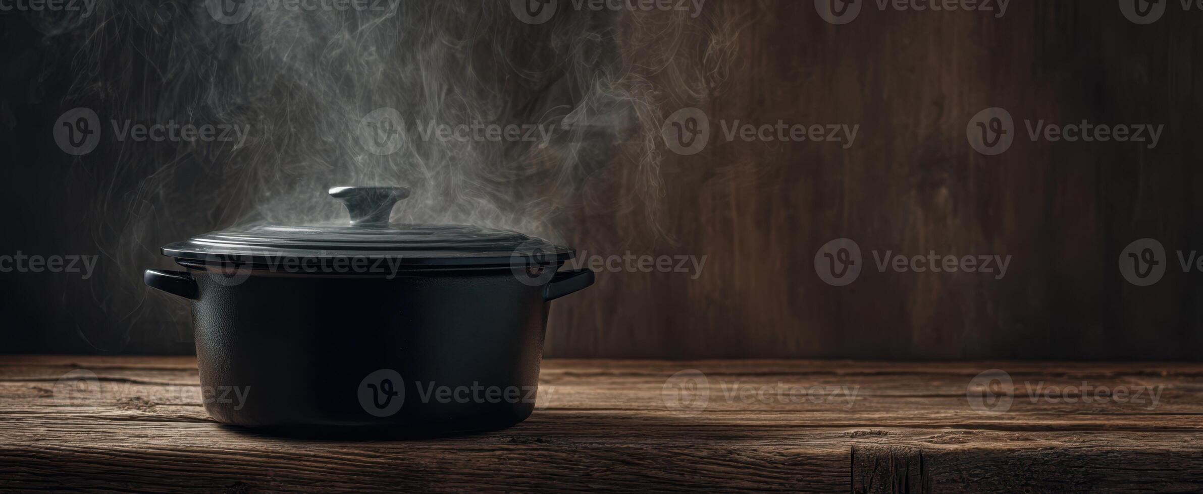 The steaming black pot on a rustic wooden table creates a cozy atmosphere. photo