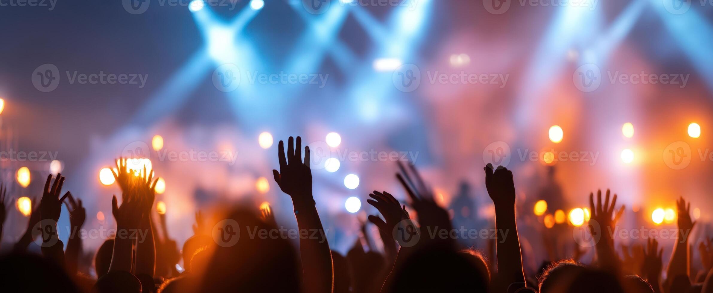 The vibrant crowd with hands raised at a lively concert event photo