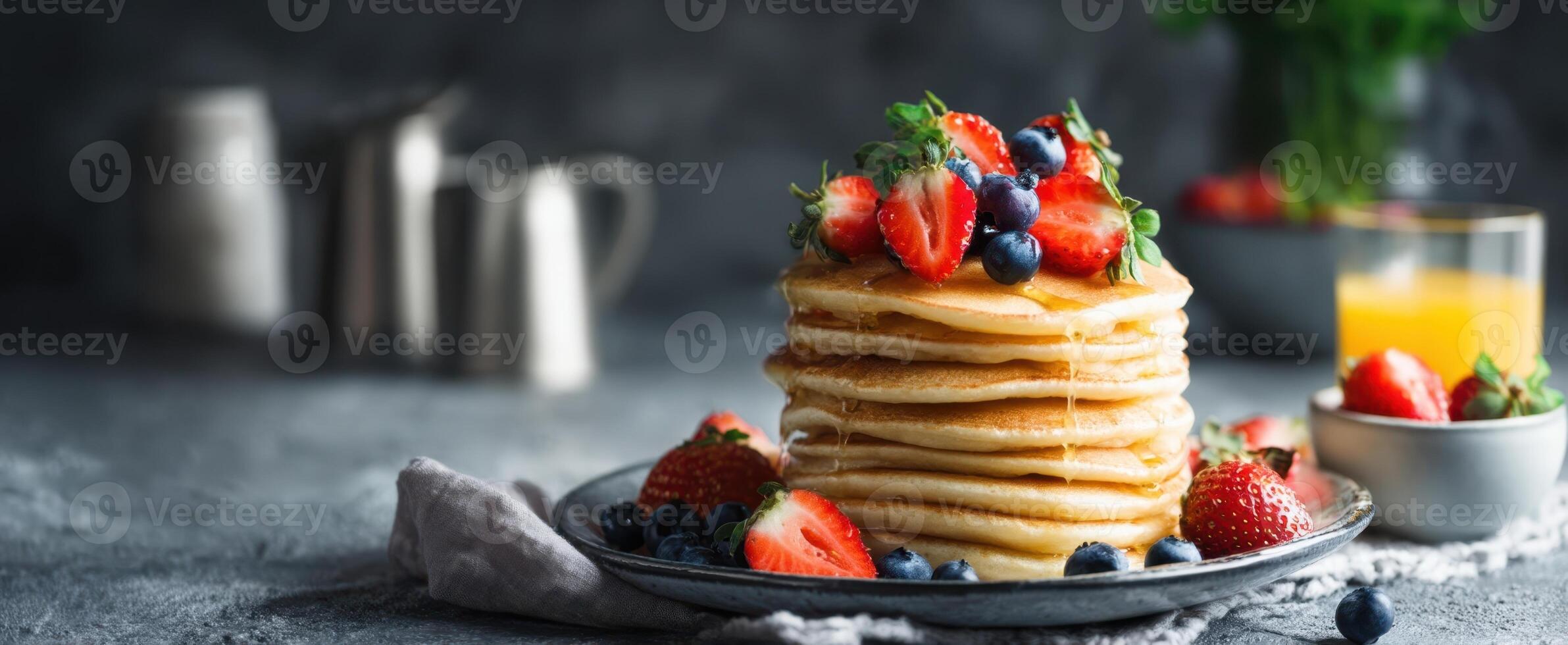 Stack of pancakes with berries and syrup on a plate photo