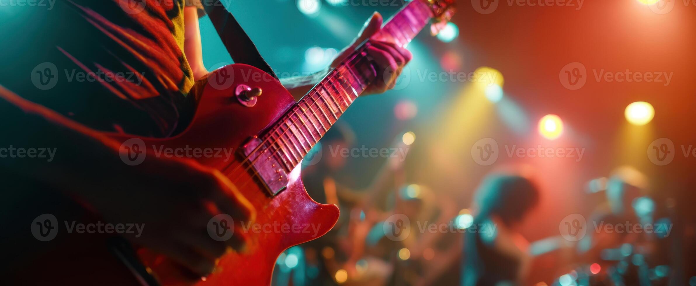 The guitarist illuminated by colorful lights during a vibrant live performance. photo