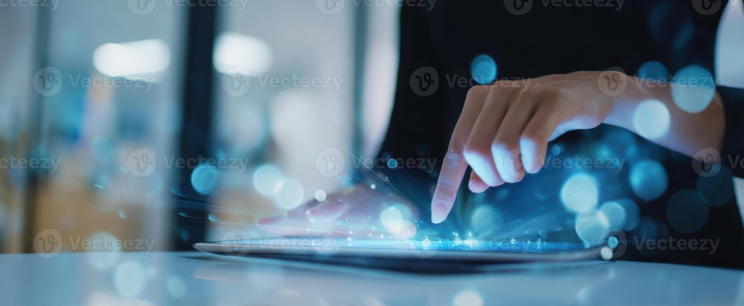 The tablet interface illuminated by a finger's touch in a digital workspace. photo