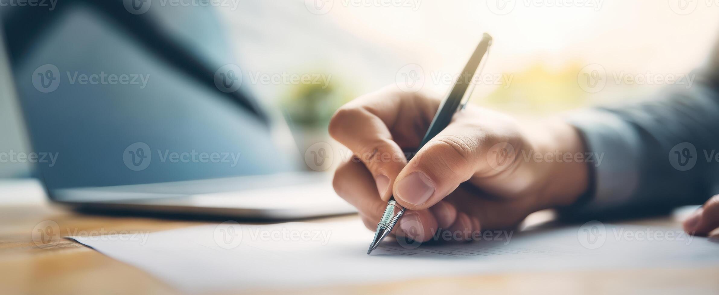 The focused hand writing with a pen on a sheet of paper in an office. photo