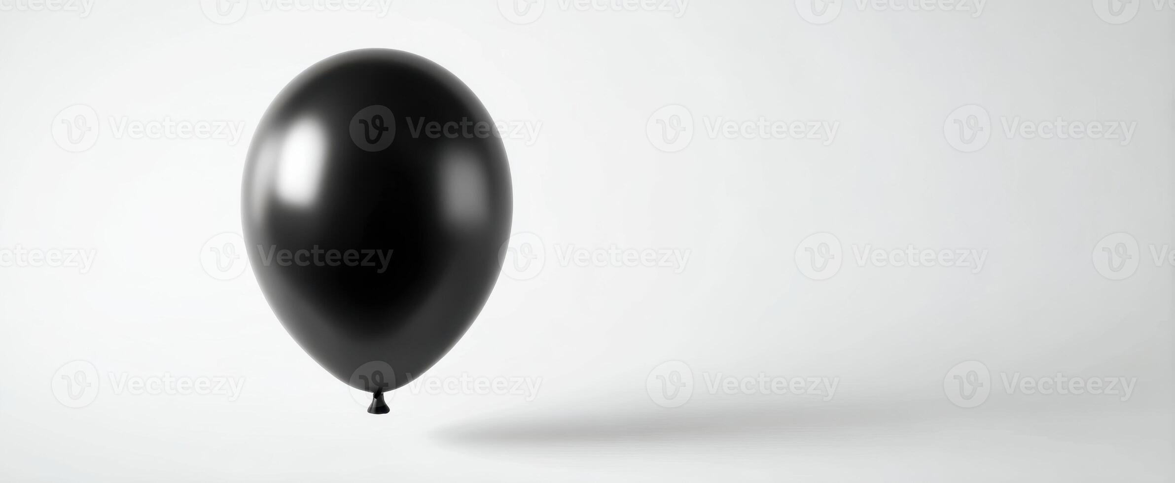 The elegant black balloon floating against a minimalistic white background. photo