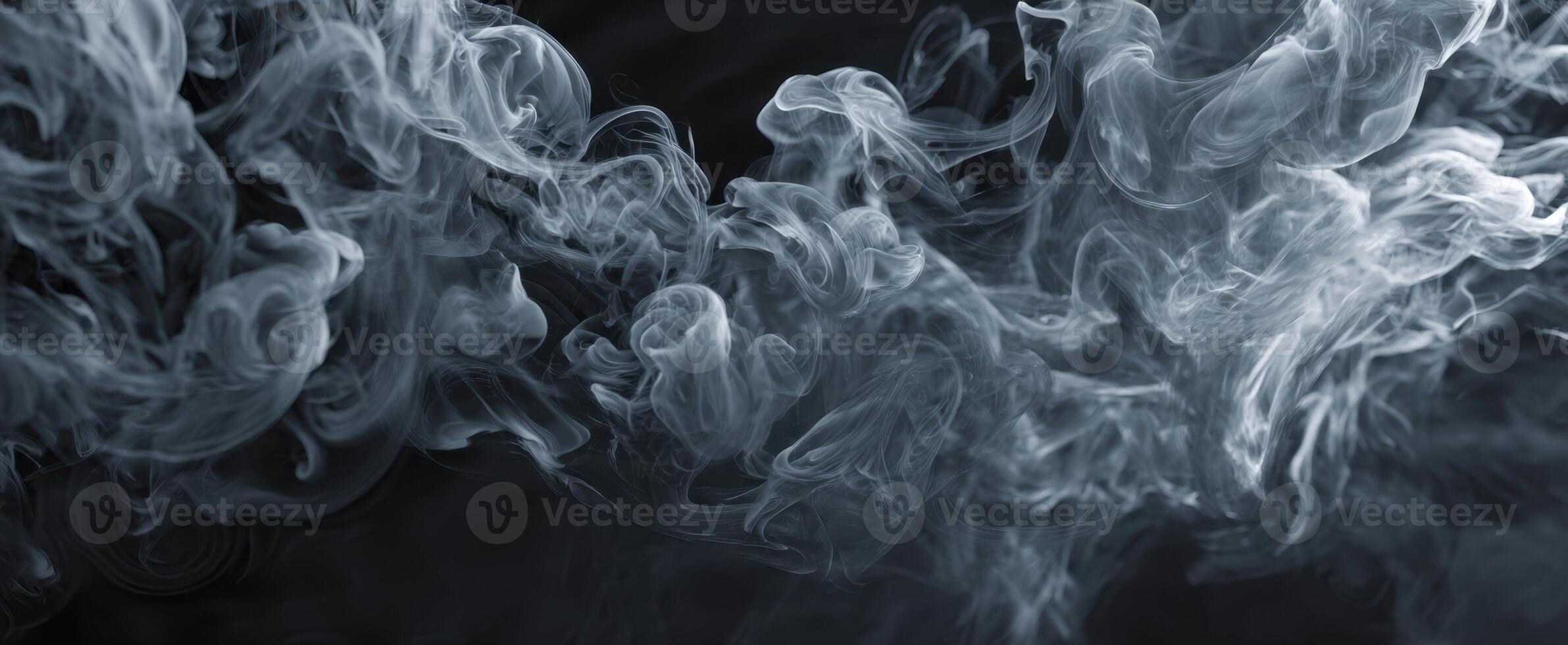 The ethereal swirls of smoke dancing in a mysterious dark background. photo