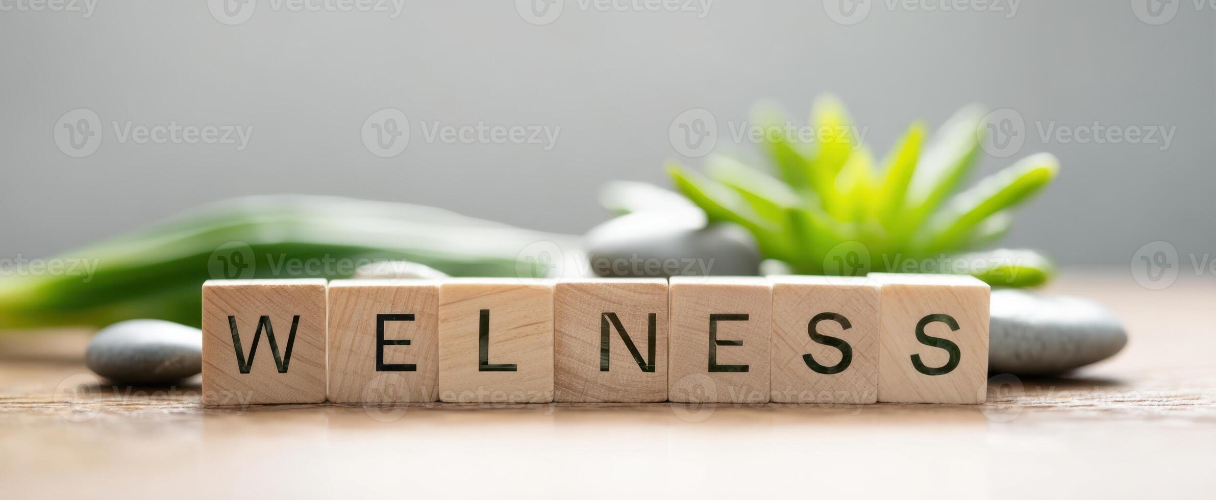 The Wooden Blocks Displaying Wellness Surrounded by Nature Elements and Stones photo