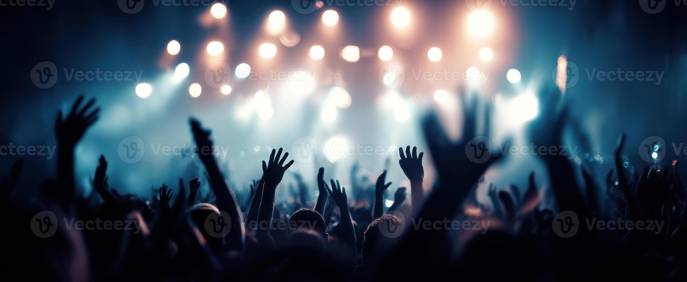 The vibrant crowd enjoying an electrifying concert with glowing lights. photo