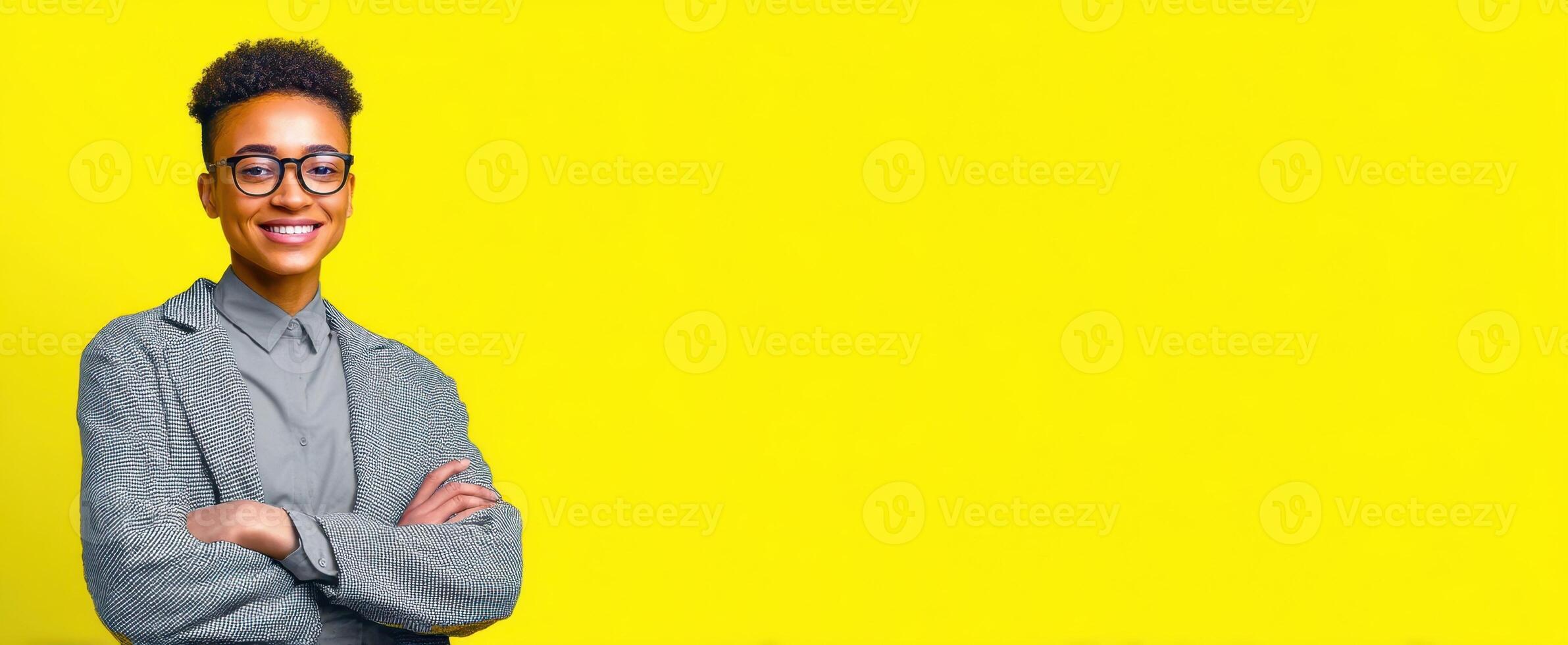 The confident young professional smiling against a vibrant yellow background. photo