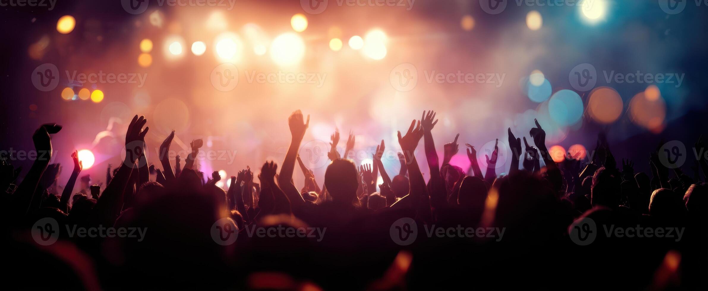 The energetic crowd enjoying a live music performance illuminated by colorful lights. photo