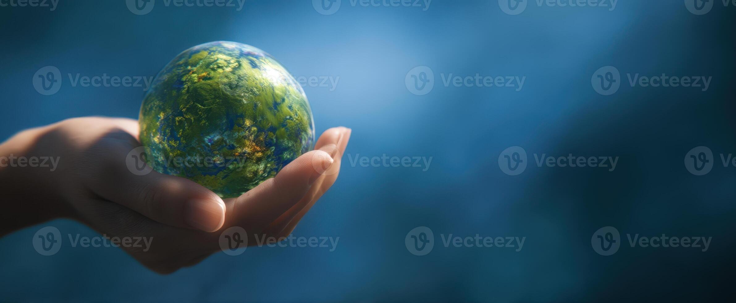The hand holds a miniature globe symbolizing global unity and environmental care. photo