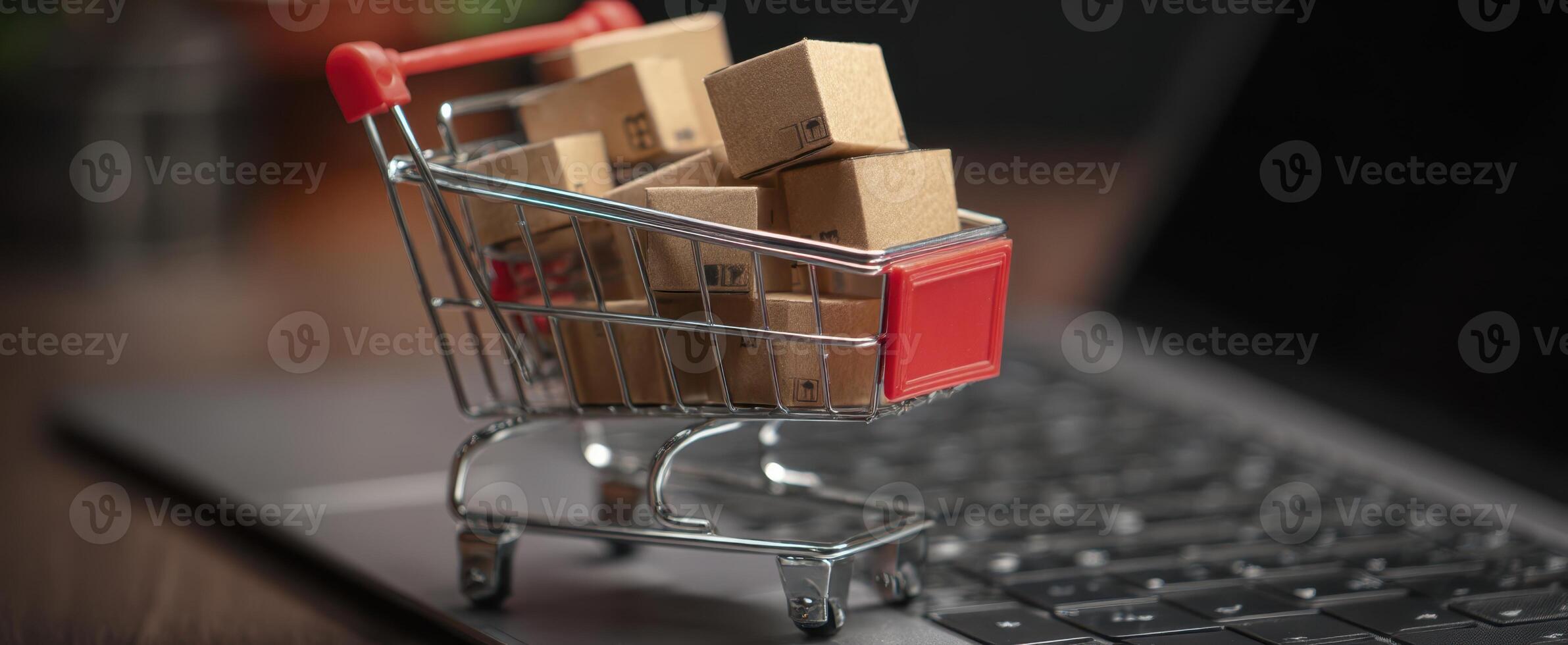 The shopping cart filled with packages on a laptop keyboard in a home office. photo