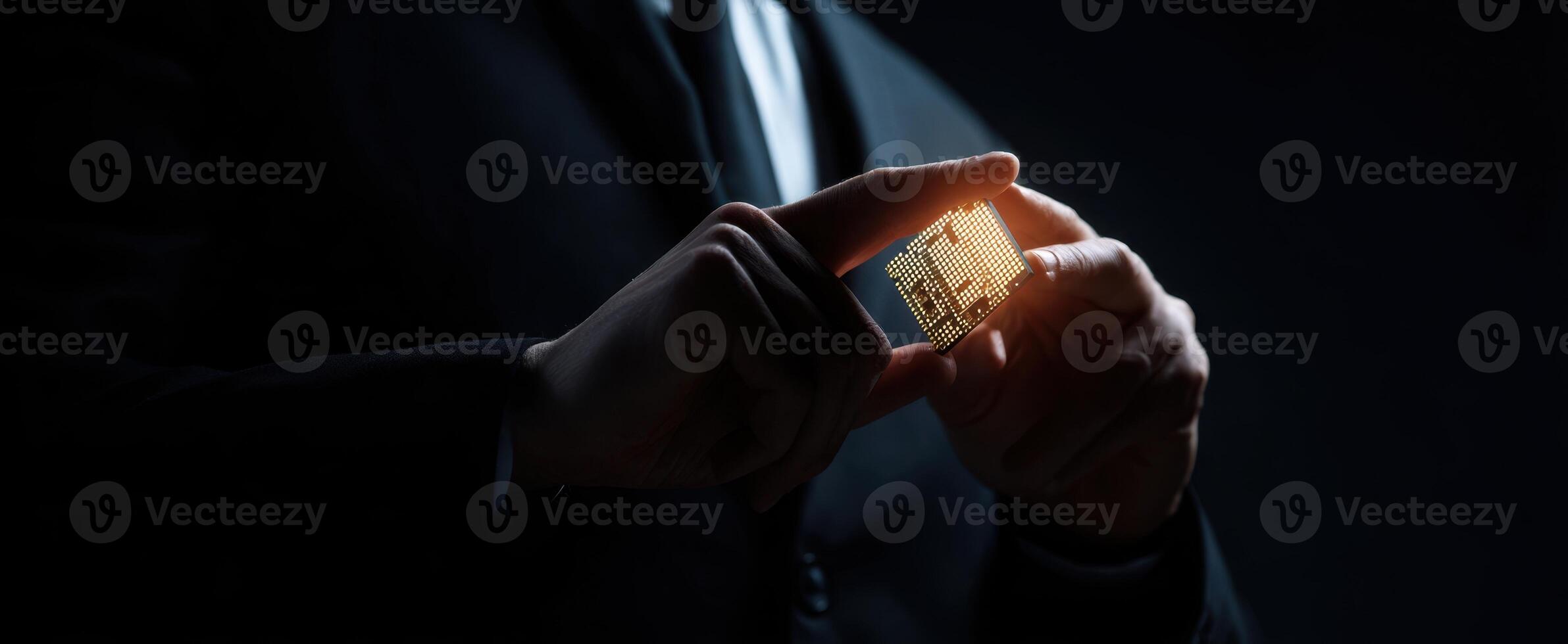The businessman showcasing a glowing microchip in a dark environment. photo