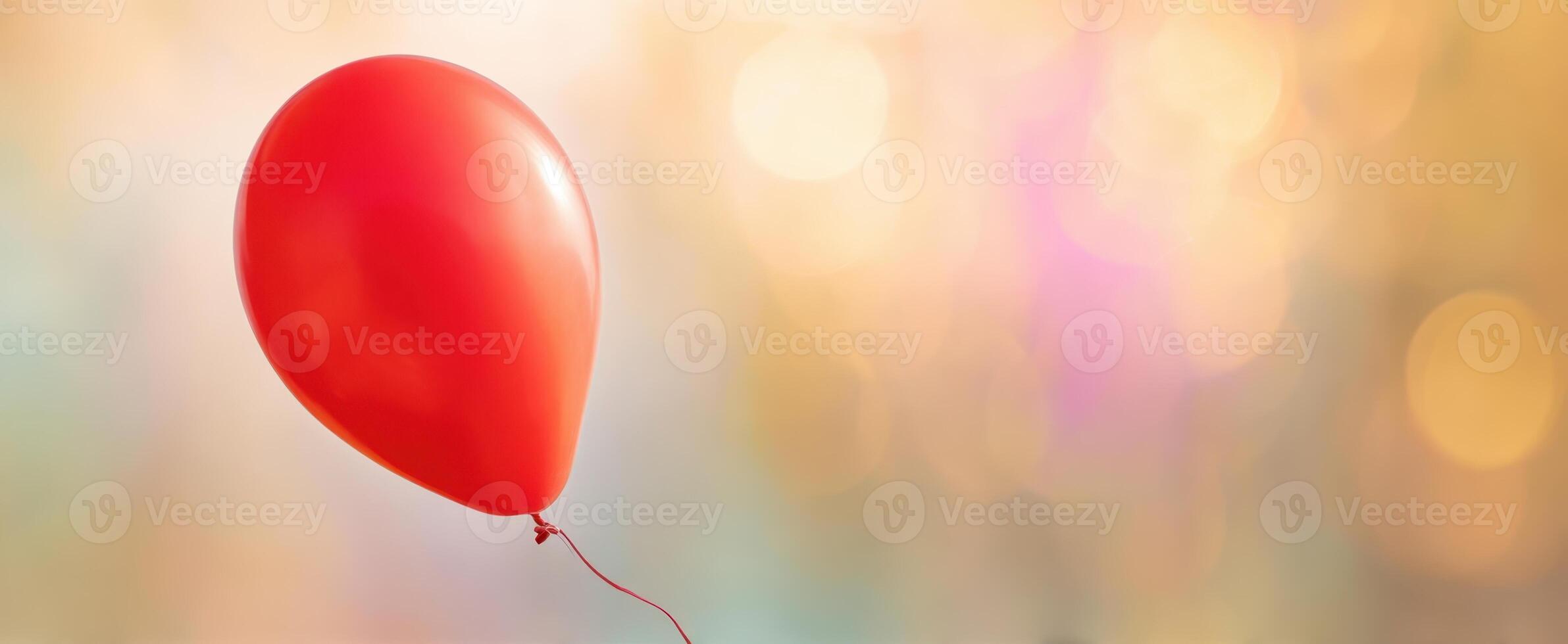 The vibrant red balloon floating against a dreamy bokeh background. photo