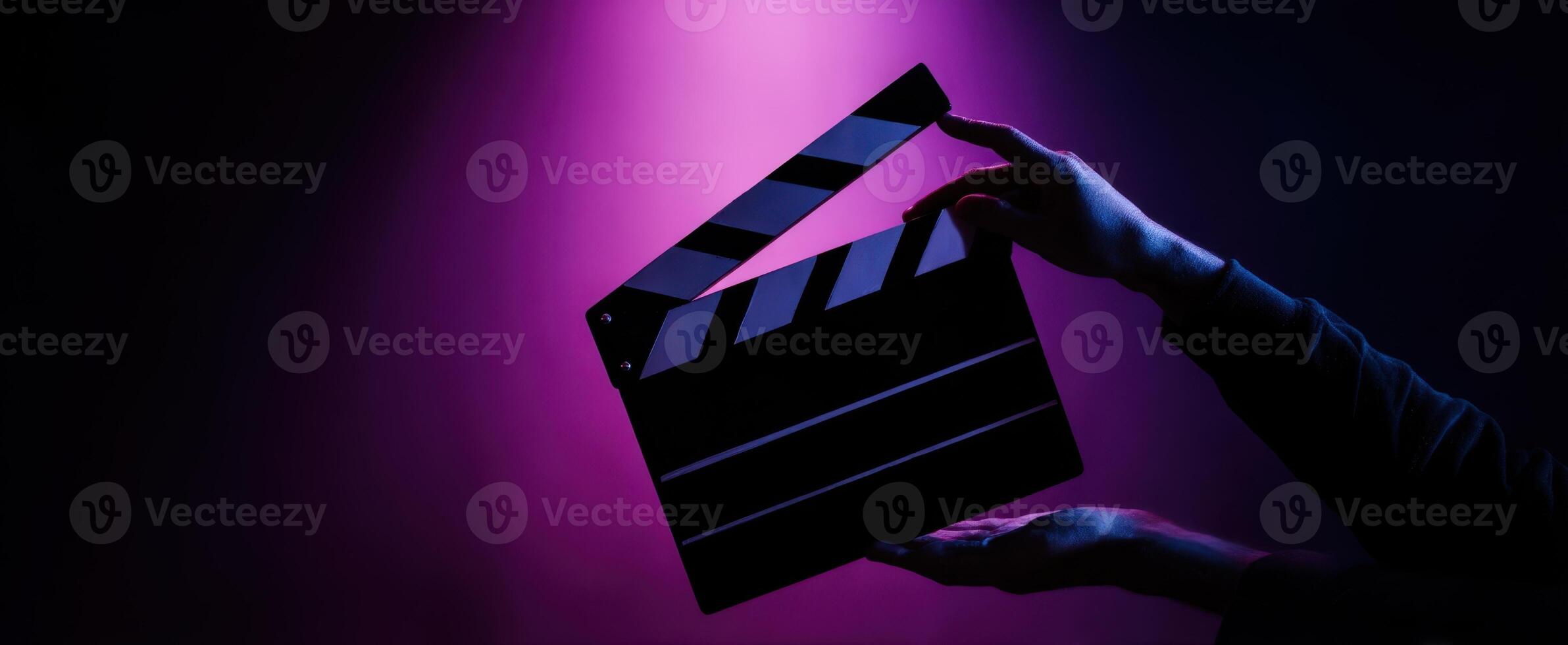 The clapperboard illuminated in a dramatic purple lighting setup. photo