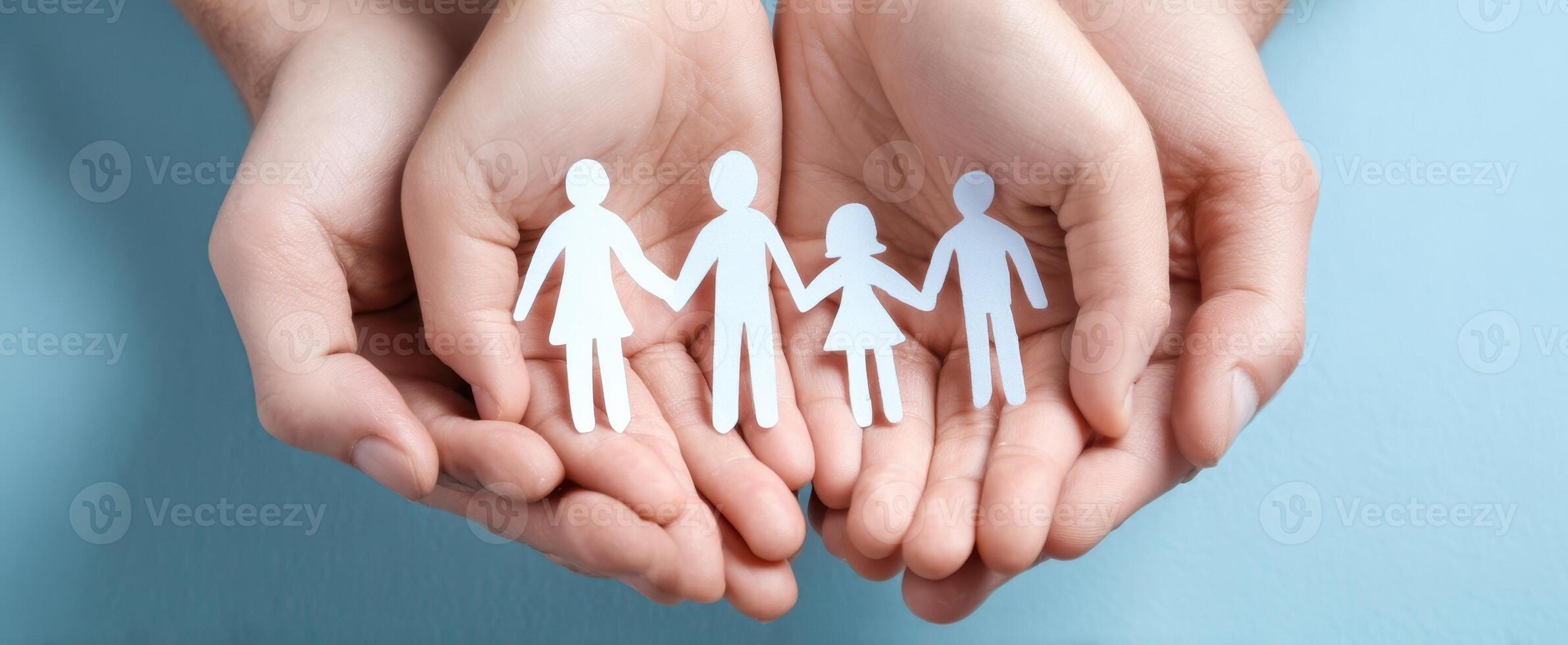 The hands holding paper figures representing family and unity in a supportive environment. photo