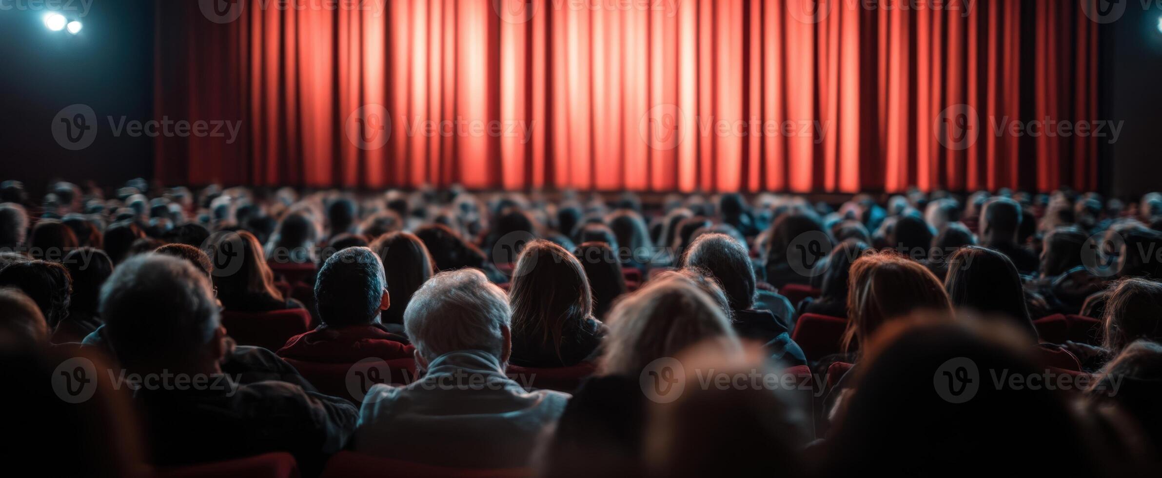 The audience eagerly awaits the performance behind the red curtains. photo