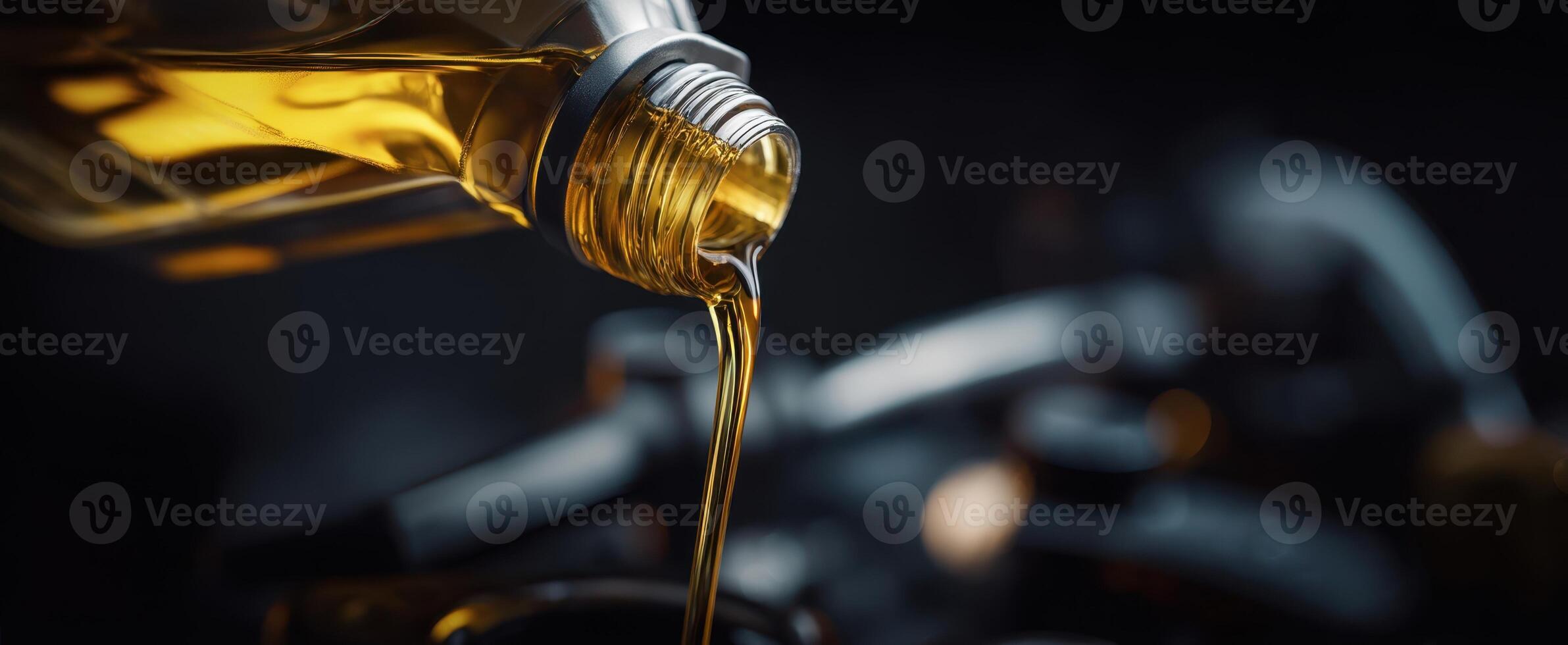 The bottle pouring golden oil onto a dark kitchen surface. photo