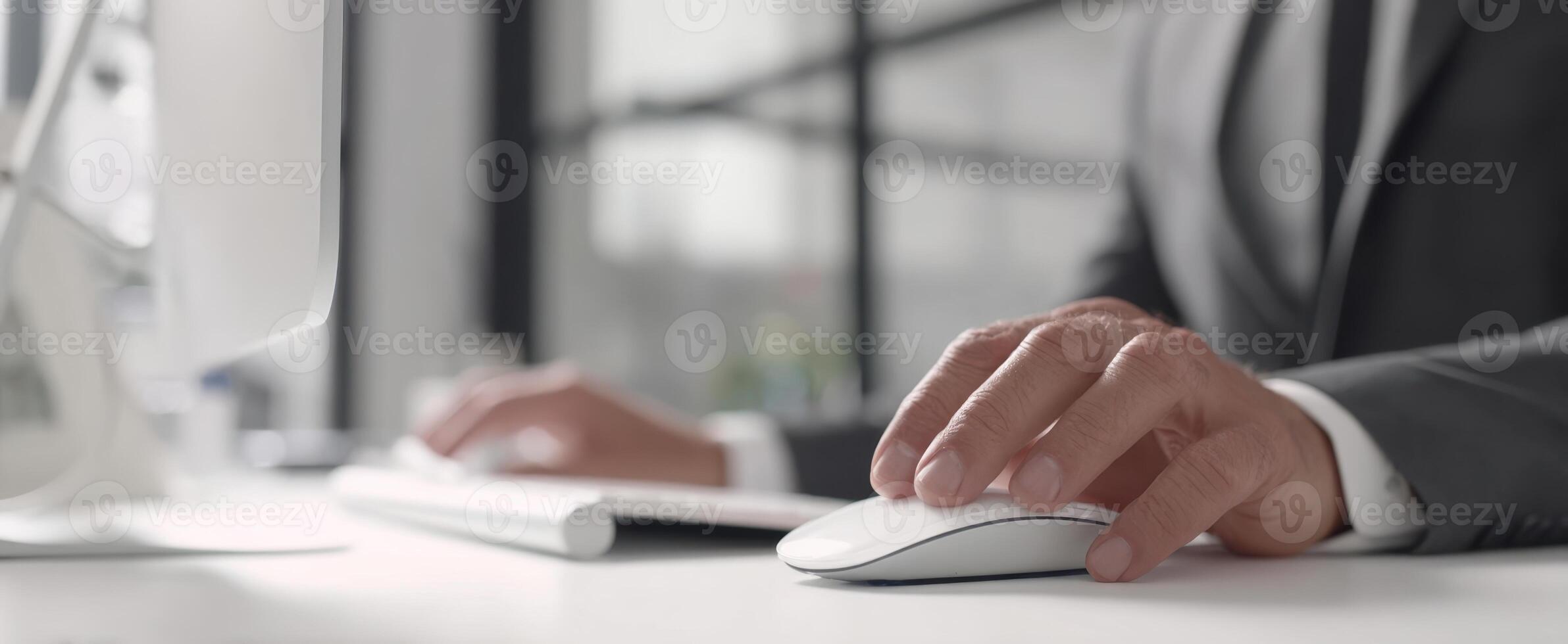 The focused hand using a computer mouse in a modern office setting. photo