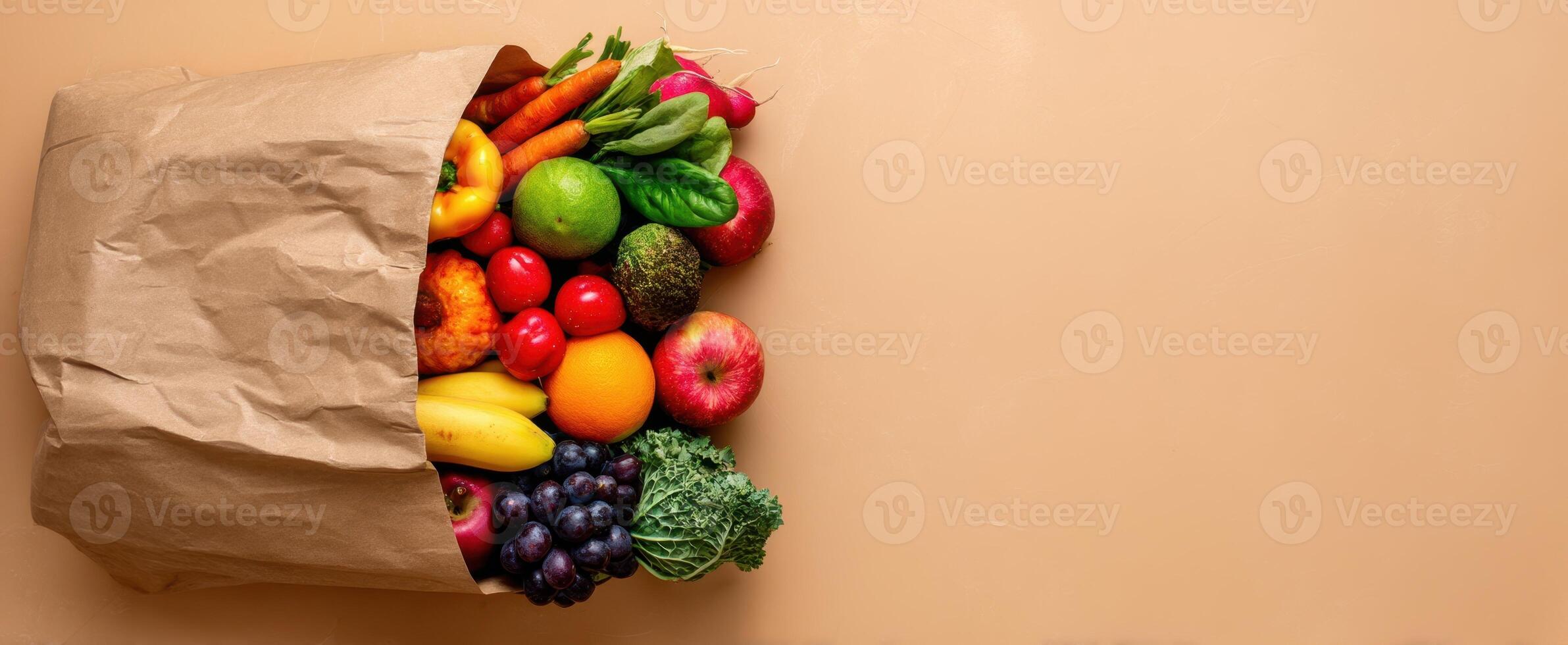 The vibrant assortment of fresh fruits and vegetables spilling from a paper bag photo