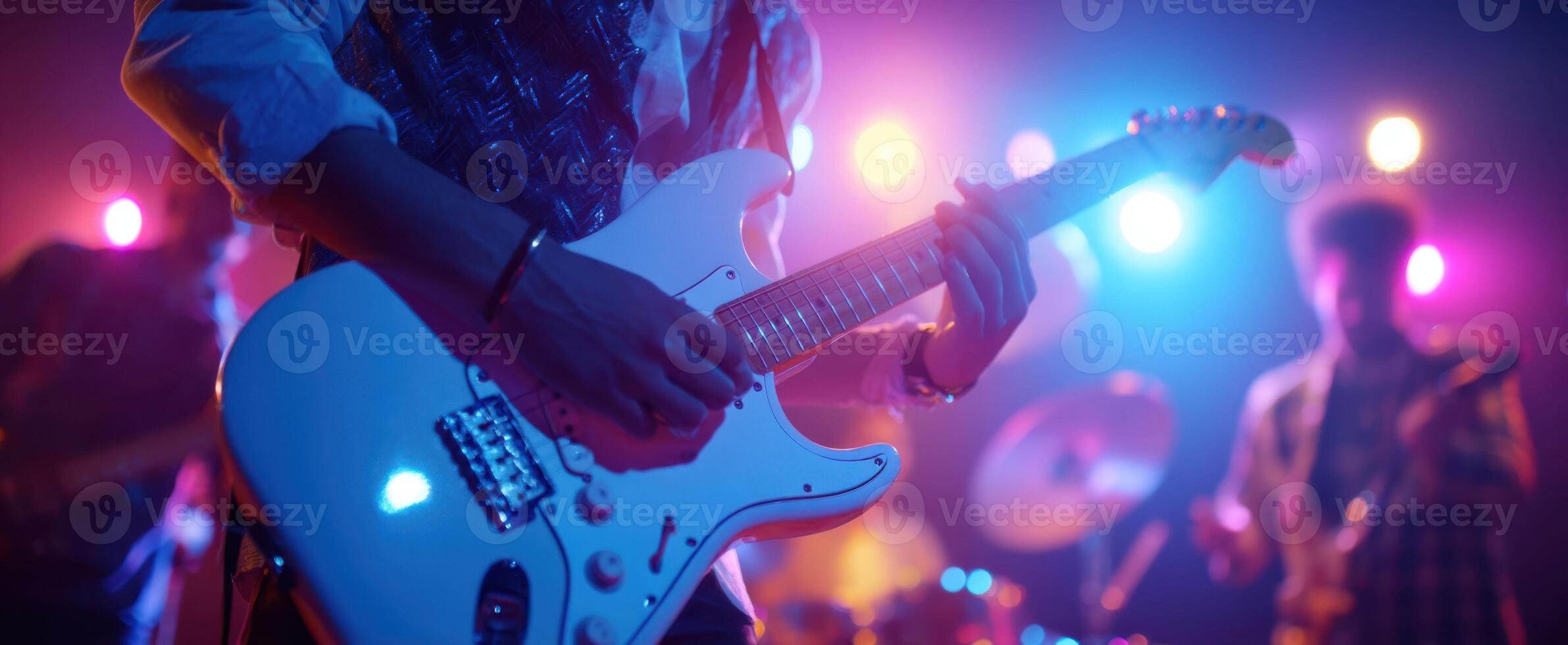 The guitarist performs passionately on stage with vibrant lighting effects. photo