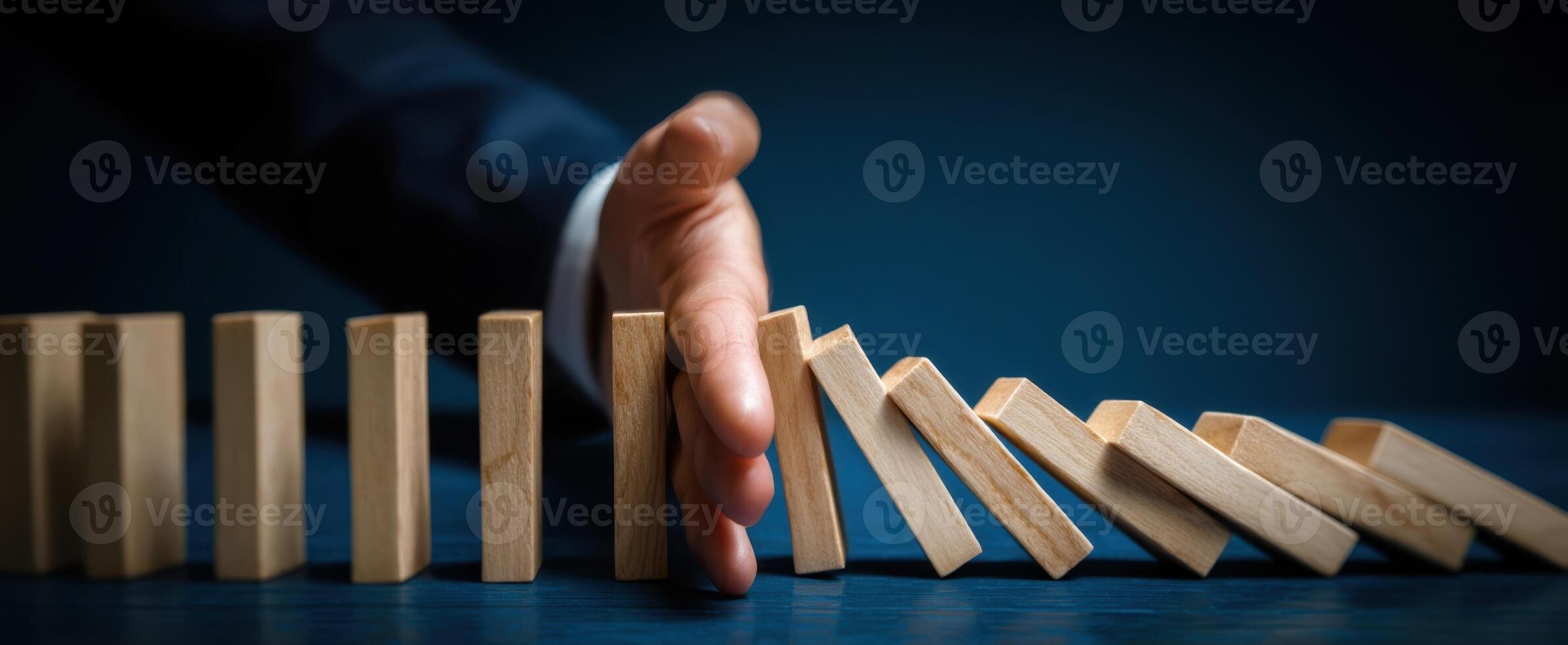 The Hand Stopping Falling Dominoes to Prevent Failure and Ensure Success photo