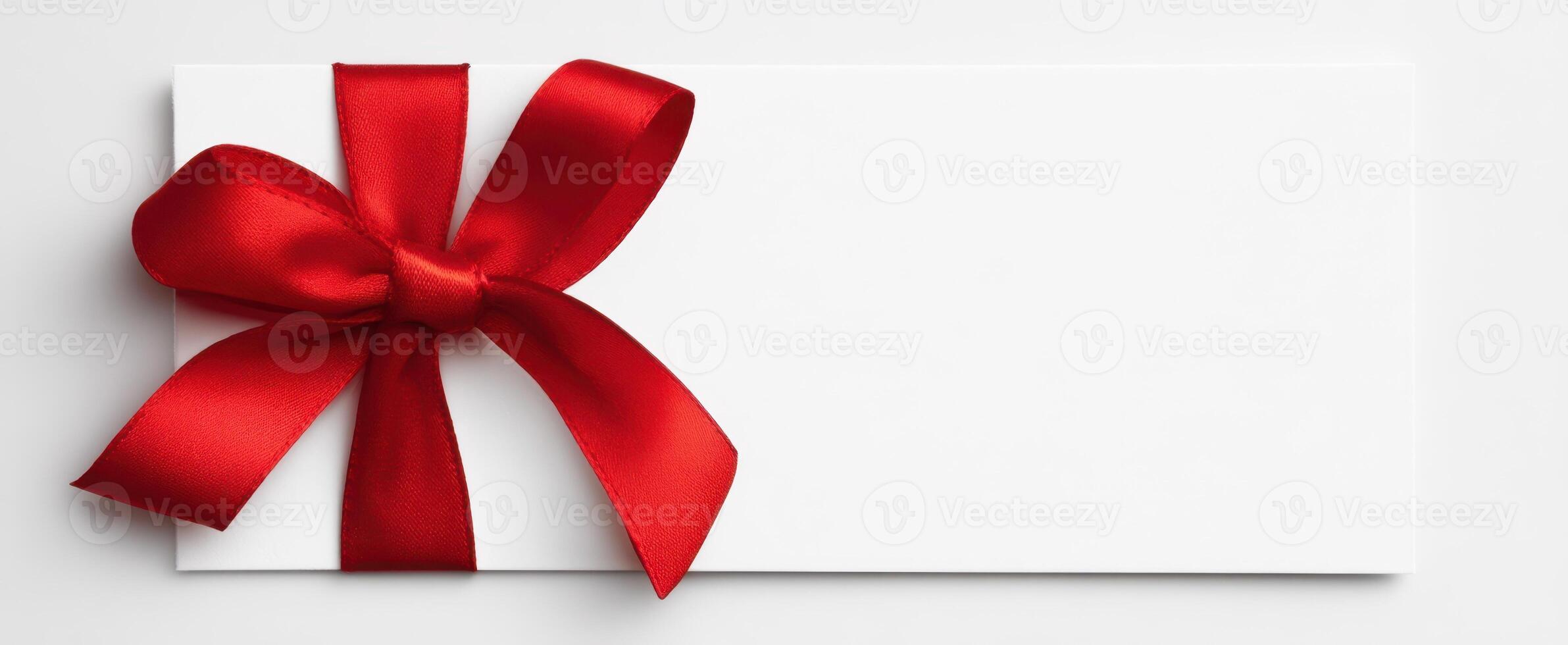 The elegant gift card with a striking red ribbon and bow delicately arranged. photo