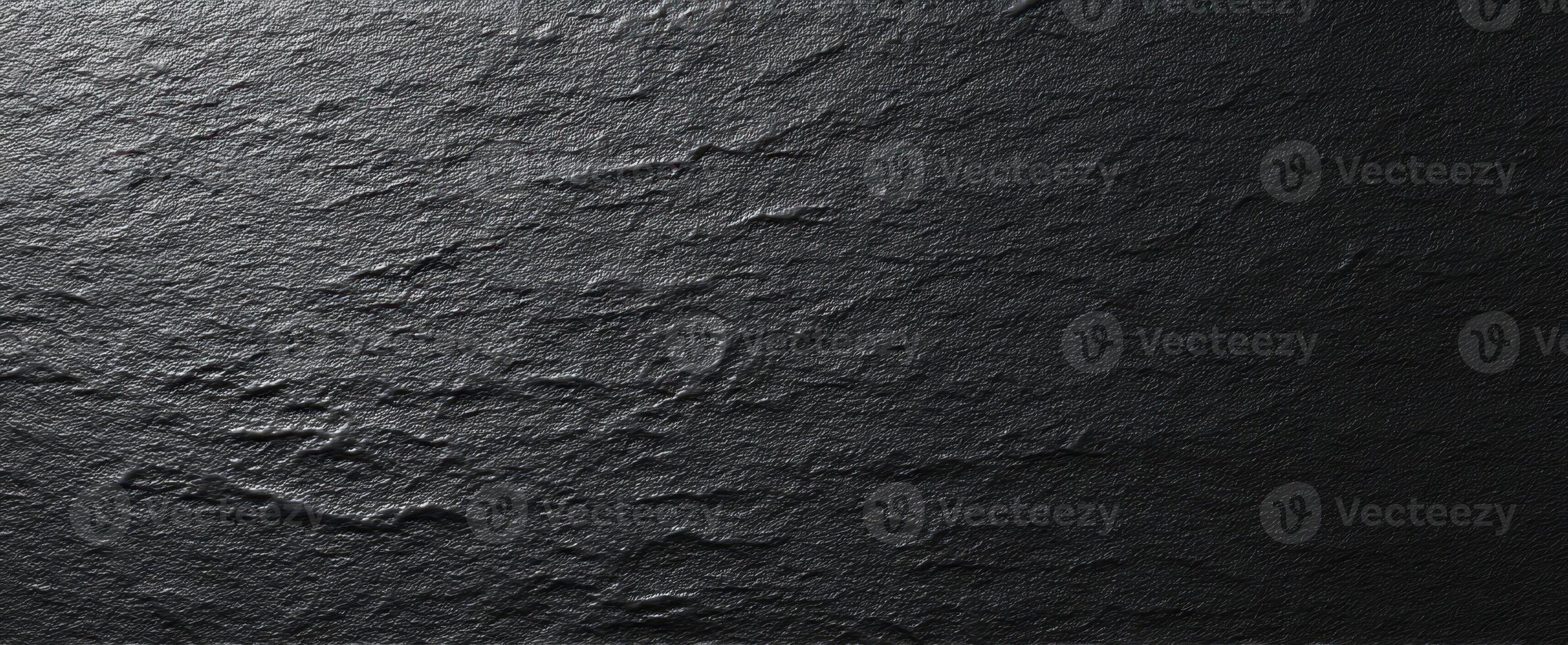 The textured black slate surface with elegant natural patterns and variation. photo