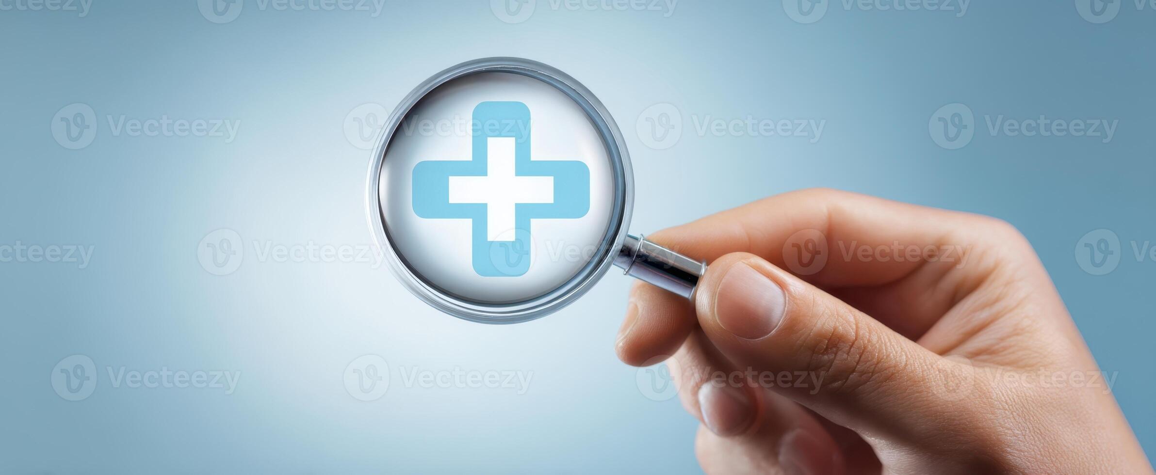The hand holding a magnifying glass over a medical cross symbol. photo