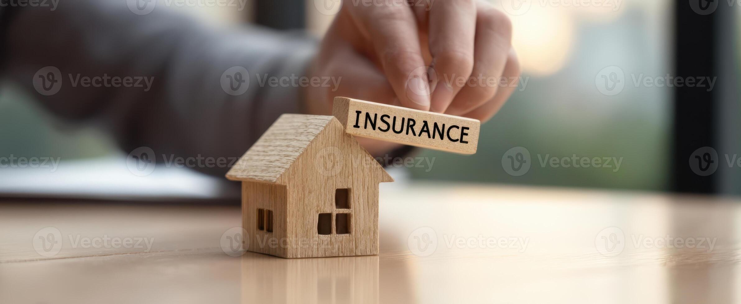 The wooden house model with an insurance sign for home protection. photo