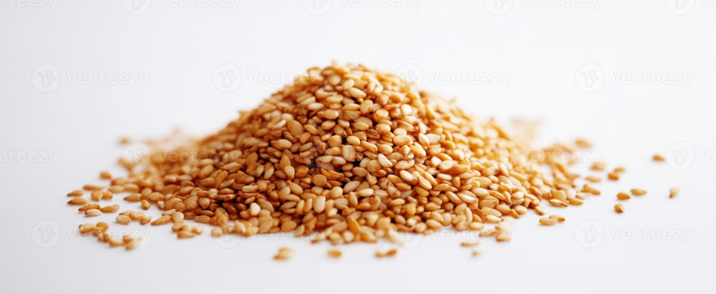 The golden pile of sesame seeds on a white background. photo