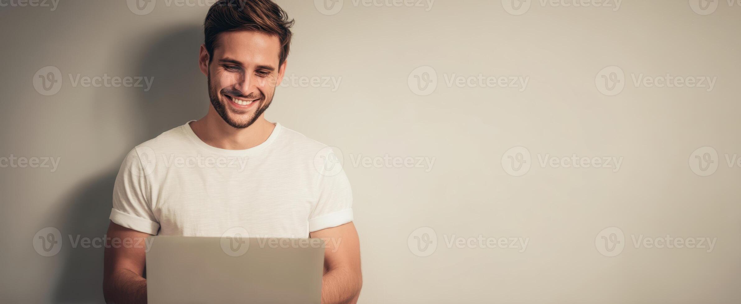 The smiling man using a laptop in a relaxed, modern home environment. photo