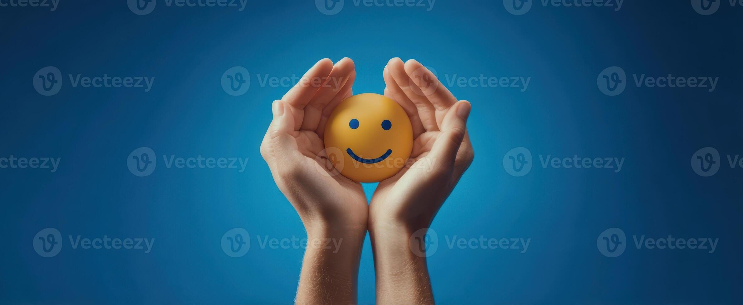 The hands holding a cheerful smiley face against a vibrant blue background. photo