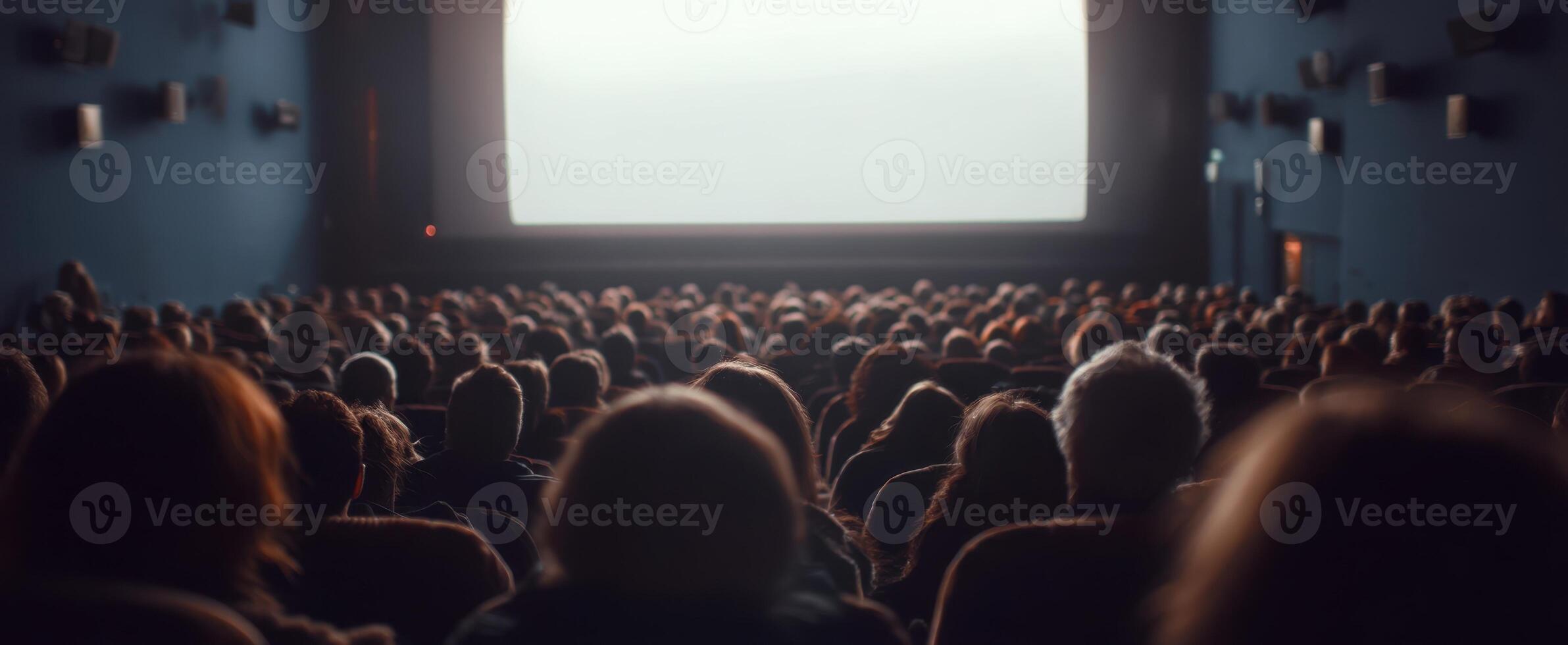 The audience captivated by the blank screen in a movie theater. photo