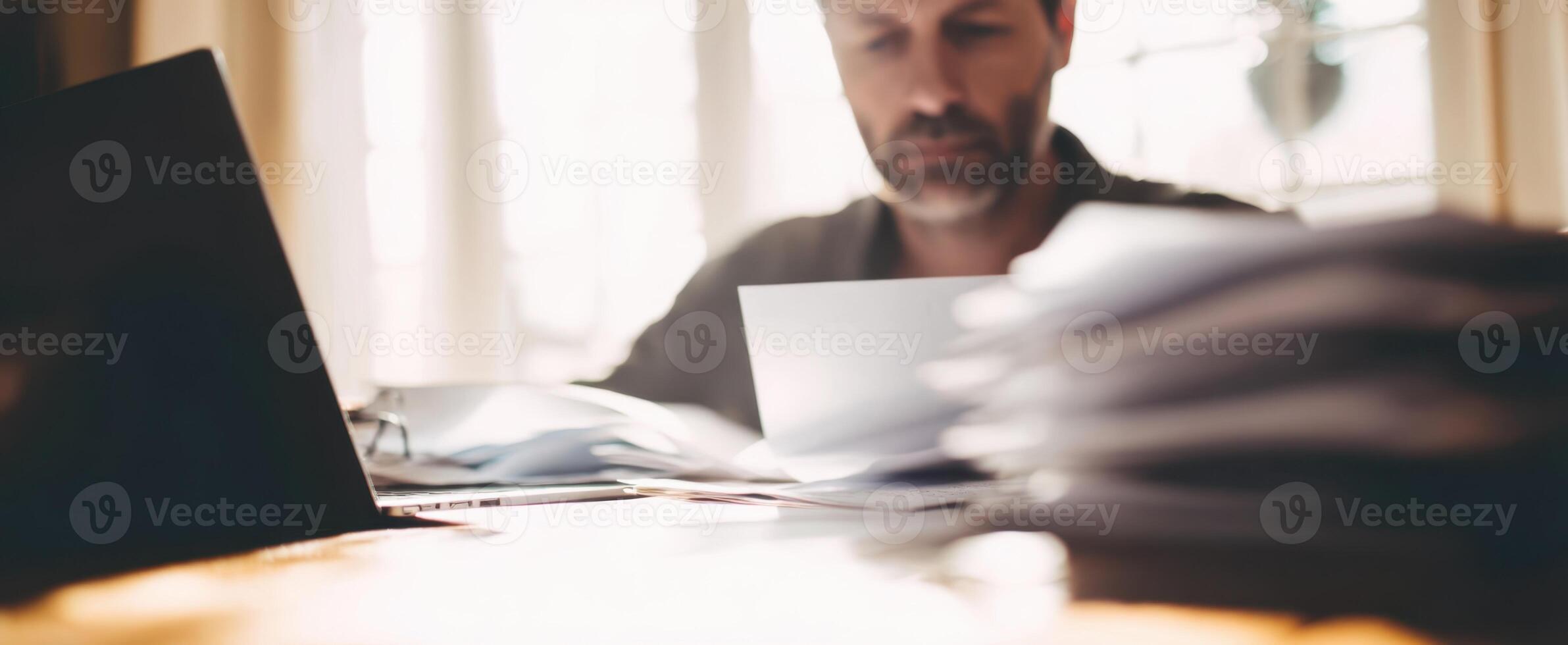 The focused man reviewing important documents at his modern workspace. photo