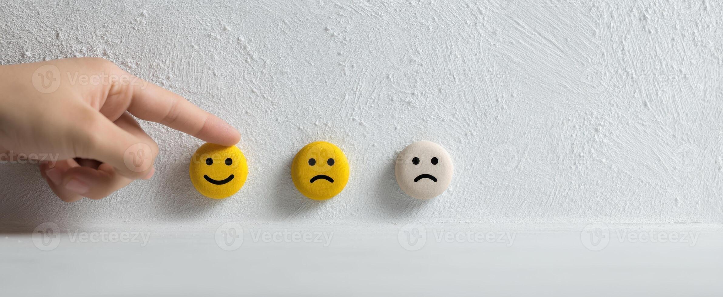 The hand pointing at three emoticon faces representing different emotions photo
