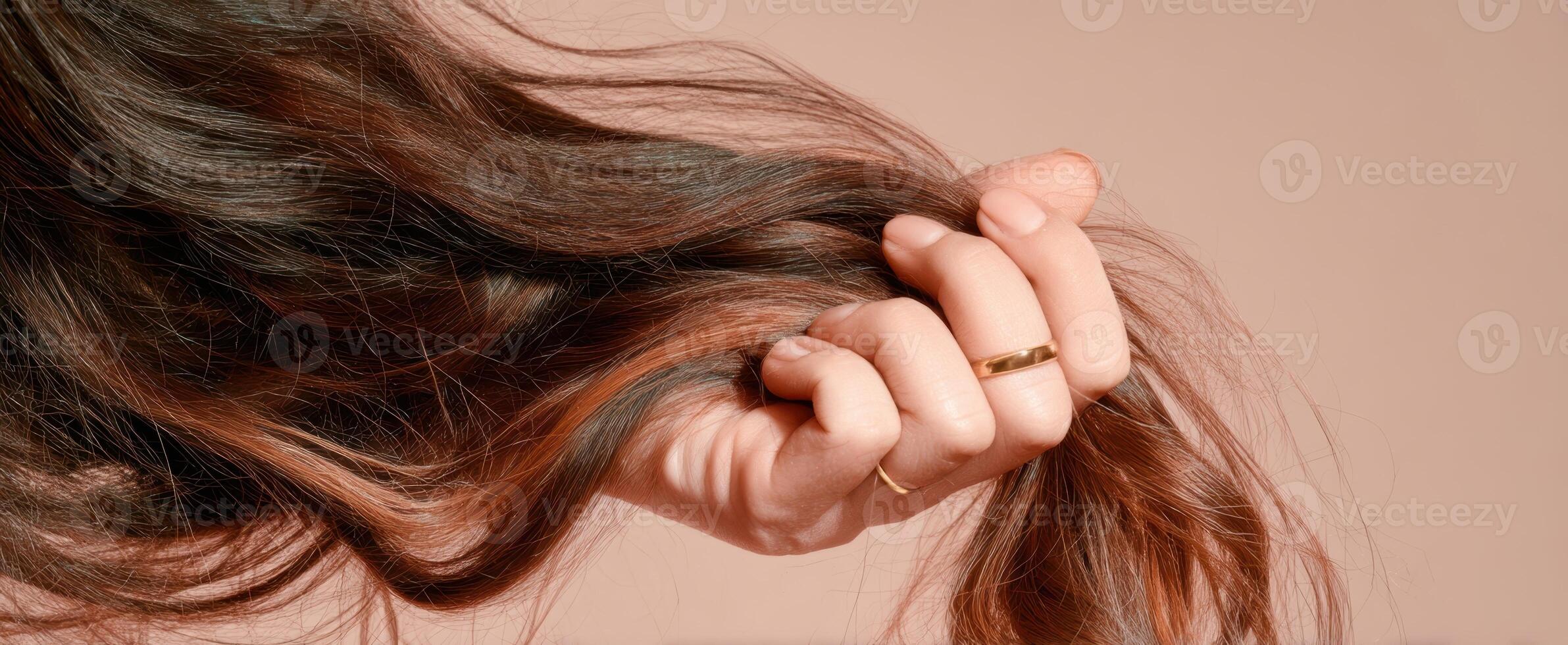 The Hand Grasping Beautiful Long Hair Against a Soft Background photo