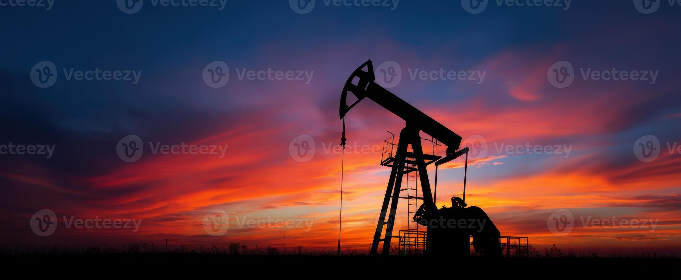 The oil pumpjack silhouetted against a vibrant sunset sky photo