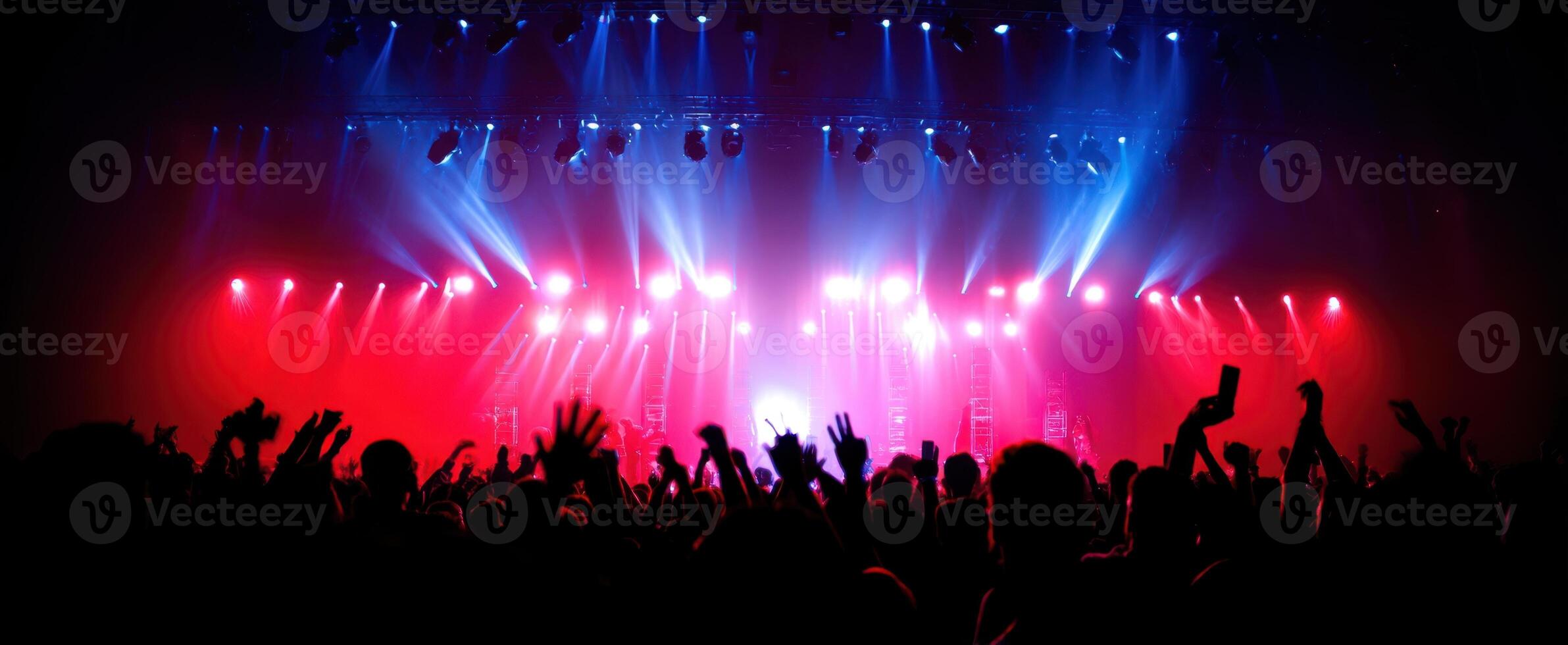 The vibrant atmosphere of a concert with energetic audience and colorful lights. photo